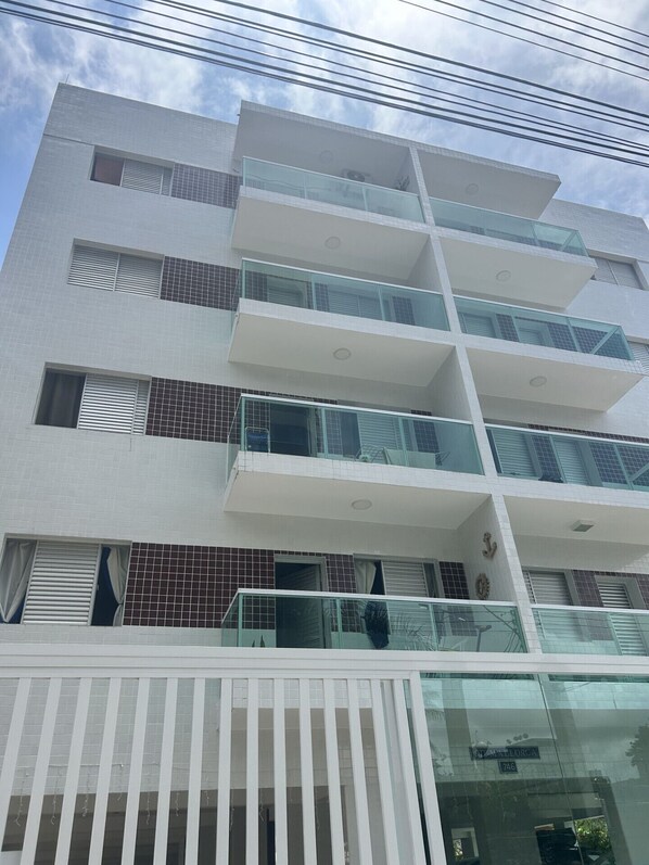 A multi-story building with balconies and a gated entrance. - Apartment in Guarujá Enseada, 200m from the beach. (Guarujá)