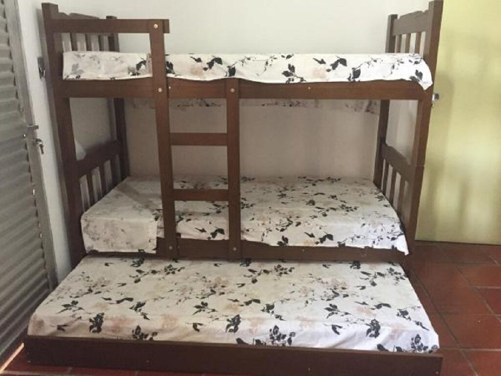Una cama litera con escalera, una cama inferior y un colchón estampado con motivos florales.