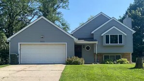 A two-story house with a garage, a front porch, and a well-maintained lawn. - Millard West Omaha 4 bed, 3 bath (Omaha)