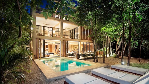 Ein modernes Haus mit Swimmingpool und Sitzgelegenheit im Freien.