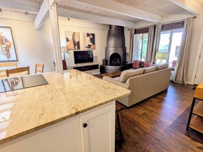 Een moderne keuken met granieten aanrechtbladen, een inbouwoven en een televisie.