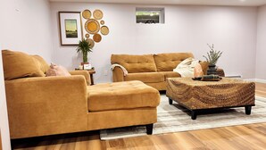 A living room with a sofa set, a coffee table, and a small side table with a plant.