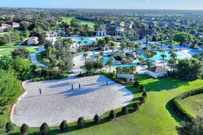 An aerial view of a resort with multiple swimming pools, a large landscaped area, and surrounding residential buildings. - Outstanding Villa at ChampionsGate Resort (Davenport)