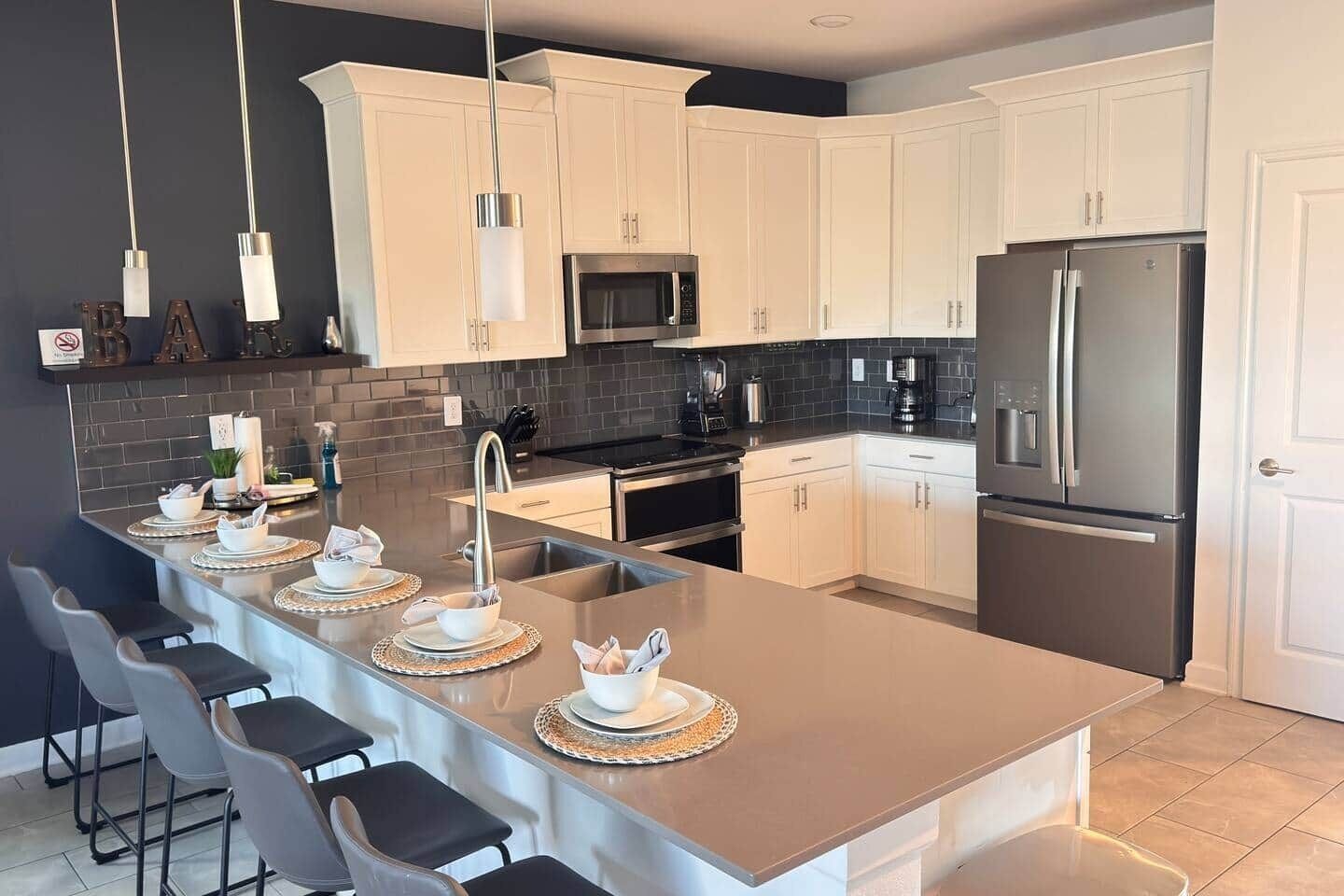 A modern kitchen with a central island, stainless steel appliances, and white cabinetry.