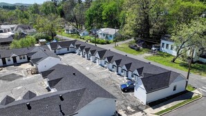 Um bairro residencial com várias casas isoladas, algumas com garagens anexas, e um estacionamento.