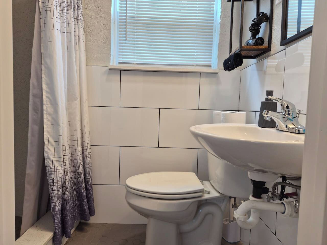 A small, clean bathroom with a toilet, sink, and window.
