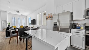 A modern kitchen with white cabinets, stainless steel appliances, and a marble countertop. - Play, work, relax, repeat: a sleek 3Bd/3.5Ba retreat near Houston’s top hubs.” (Houston)