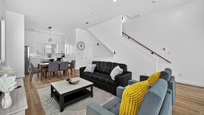 A modern living room with a sofa, coffee table, and dining area. - Play, work, relax, repeat: a sleek 3Bd/3.5Ba retreat near Houston’s top hubs.” (Houston)