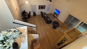 Un salon moderne avec un canapé, un téléviseur et un ventilateur de plafond.