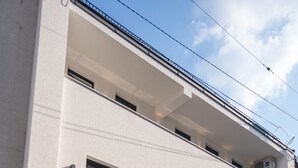 Un bâtiment moderne à deux étages, doté d’un toit plat, de nombreuses fenêtres et d’un espace de stationnement.