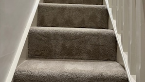 A staircase with carpeted steps and white railings.