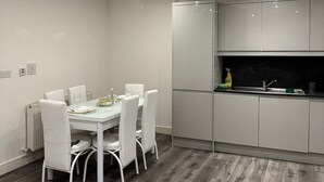 A modern kitchen with white cabinets, a built-in oven, and a sink.