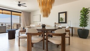 Un comedor moderno con una mesa redonda, sillas de madera y una lámpara colgante.