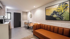 A modern living room with a sofa, a dining table, and a kitchen area. - Cozy 1-Bedroom in Dolphin Estate, Ikoyi with Wi-Fi, DSTV & Modern Amenities (Lagos)