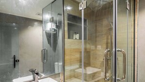 A modern bathroom with a glass-enclosed shower, a white sink, and a marble countertop. - Cozy 1-Bedroom in Dolphin Estate, Ikoyi with Wi-Fi, DSTV & Modern Amenities (Lagos)