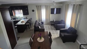 A modern apartment with a dining area, living room, and kitchen.
