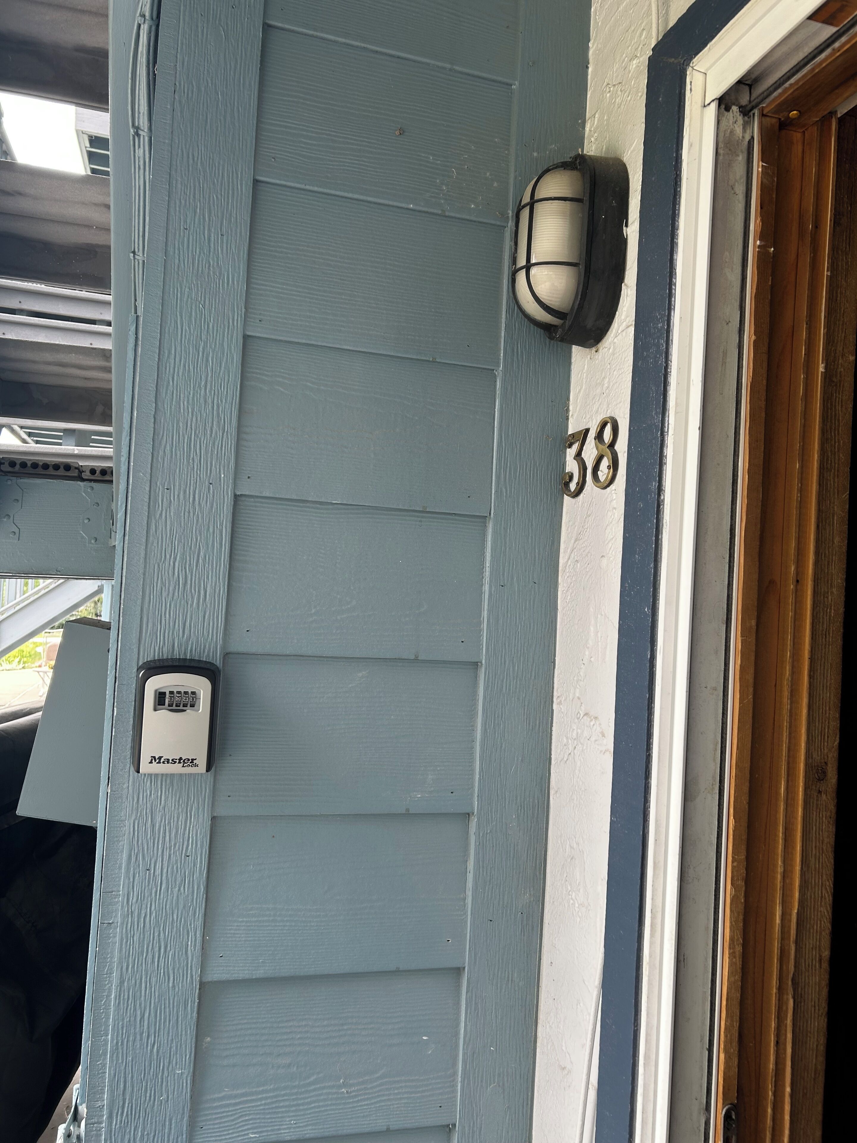 Une maison portant le numéro 38, une boîte aux lettres et une porte avec un cadre en bois.