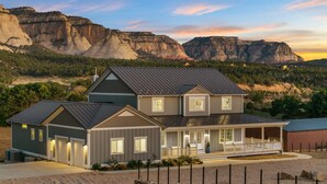 A two-story house with a garage, a covered porch, and a driveway. - East Zion Modern Farmhouse, Sleeps 14, Hot Tub, Fire Pit & Chef Kitchen (Orderville)