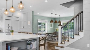 A modern kitchen with white cabinets, a large island, and pendant lighting. - East Zion Modern Farmhouse, Sleeps 14, Hot Tub, Fire Pit & Chef Kitchen (Orderville)