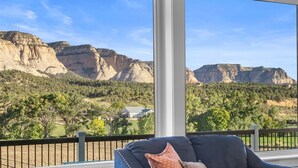 A room with a large window offering a view of a mountainous landscape. - East Zion Modern Farmhouse, Sleeps 14, Hot Tub, Fire Pit & Chef Kitchen (Orderville)