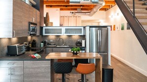 A modern kitchen with a central island, bar stools, and stainless steel appliances.