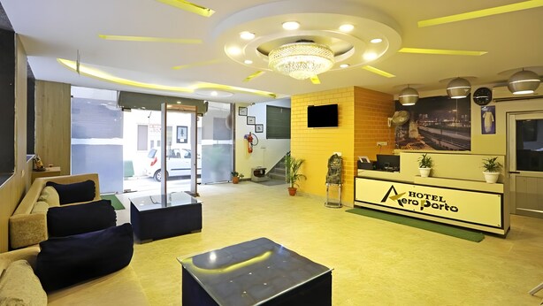 Hall d'albergo con reception, area relax e lampadario.