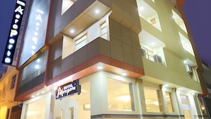 Un hotel moderno a più piani, con balconi su ogni livello e una segnaletica ben visibile.
