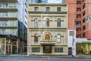 A building with a sign reading 'SEFTON' at the entrance, a parking sign, and a pedestrian crossing. - Modern Victorian Luxury in Melbourne CBD | 3BR 2BA (Melbourne)