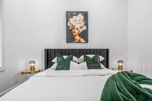 A modern bedroom with a large bed, two bedside tables, and a wall-mounted artwork. - Modern Victorian Luxury in Melbourne CBD | 3BR 2BA (Melbourne)