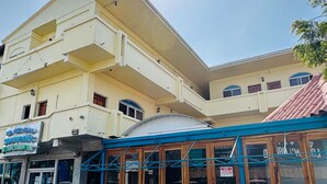 Un edificio de varios pisos con una tienda en la planta baja y un área de estar al aire libre cubierta.