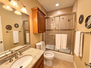 A bathroom with a granite countertop sink, a toilet, a bathtub, and a glass-enclosed shower. - Paradise Bay 8 - Two Bedroom Off The Beach (South Padre Island)