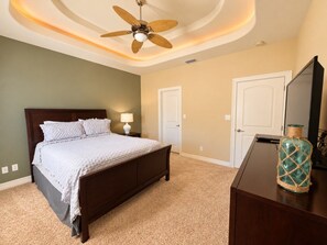 A bedroom with a bed, a ceiling fan, a dresser, and a mirror. - Paradise Bay 8 - Two Bedroom Off The Beach (South Padre Island)