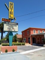 Letrero de motel que ofrece aire acondicionado, teléfono, HBO gratis y televisión por cable.