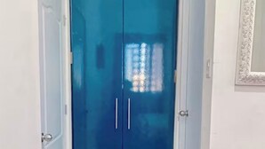 Ein Flur mit einem blauen Schrank und einem Spiegel an der Wand.
