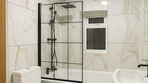 A bathroom with a toilet, a shower enclosure, a bathtub, and a sink.