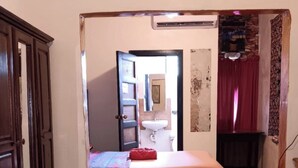 A bedroom with a bed, a wardrobe, and a bathroom visible through an open door. - MAXROOMZ (Santa Elena)