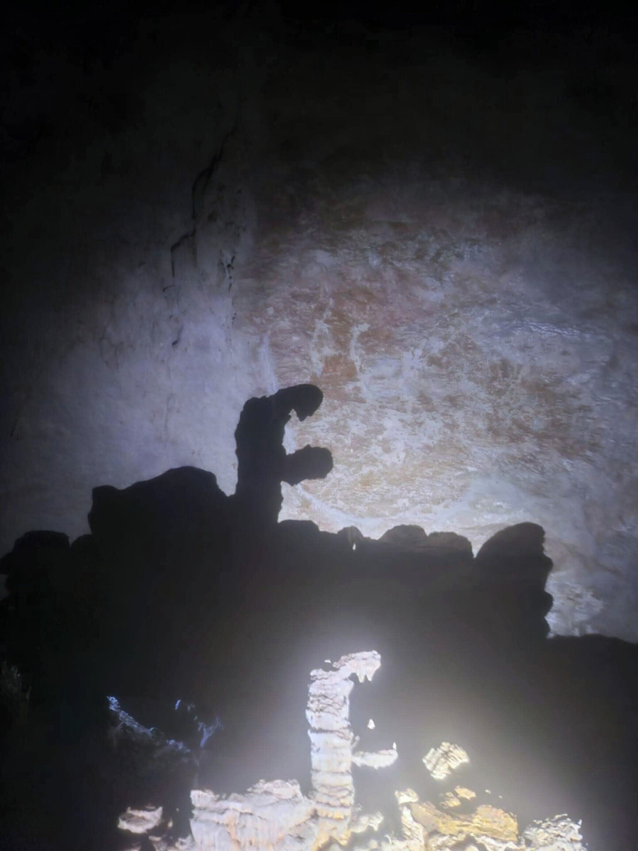 Interior de caverna com paredes irregulares e um estreito corredor.