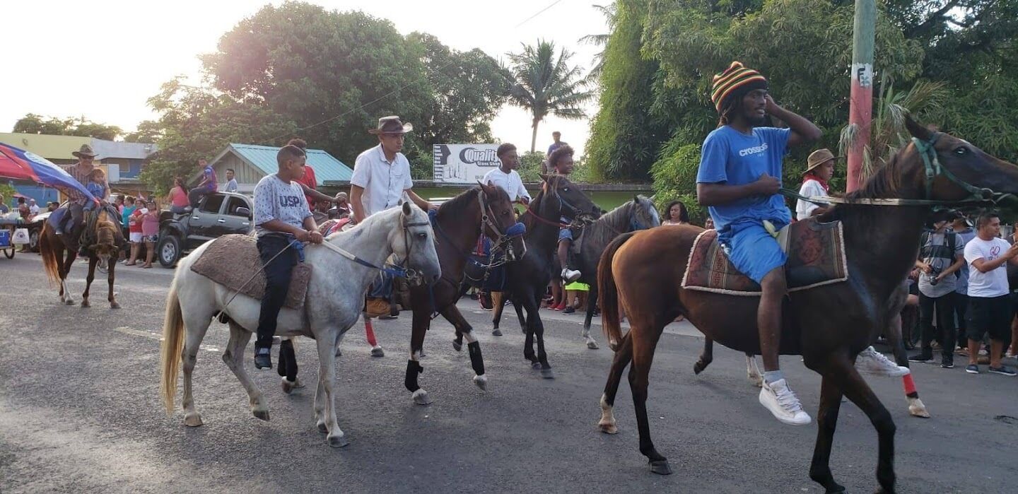 A parade with people riding horses down a street.