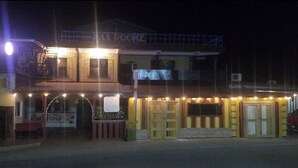 A building with a sign reading "MAX ROOMZ" at the top, featuring multiple doors and a balcony. - MAXROOMZ (Santa Elena)