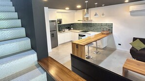 A modern kitchen with a central island, white cabinets, and a black countertop. - Great townhome with AC in Guácima, surrounded with nature and totally private (Guácima)