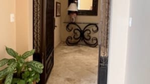 Un passadís amb una arcada decorativa, una planta en test i una làmpada.