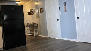 A kitchen with a black refrigerator, wooden cabinets, and a built-in shelf unit. - “Waterfront Getaway on Wheeler Lake – Private Dock & Boat Ramp” (Hillsboro)