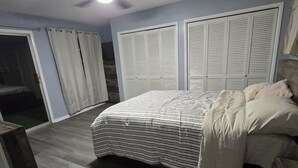 A bedroom with a bed, a ceiling fan, a wardrobe, and a sliding door. - “Waterfront Getaway on Wheeler Lake – Private Dock & Boat Ramp” (Hillsboro)