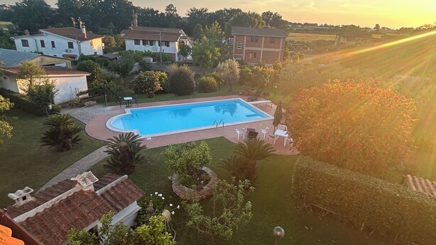 Un quartier résidentiel doté d’une piscine, entouré de verdure et de maisons.