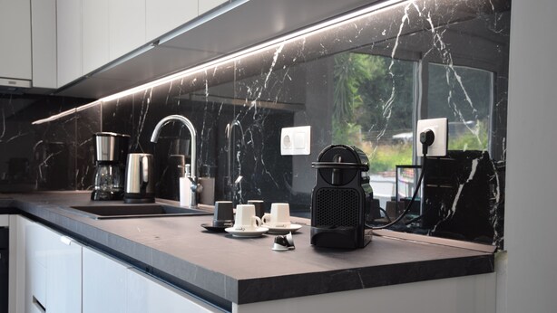 A modern kitchen with a marble countertop, a coffee maker, and a kettle. - 4 minutes by car from the beach new modern apartment in Rhodes town (Rodos)