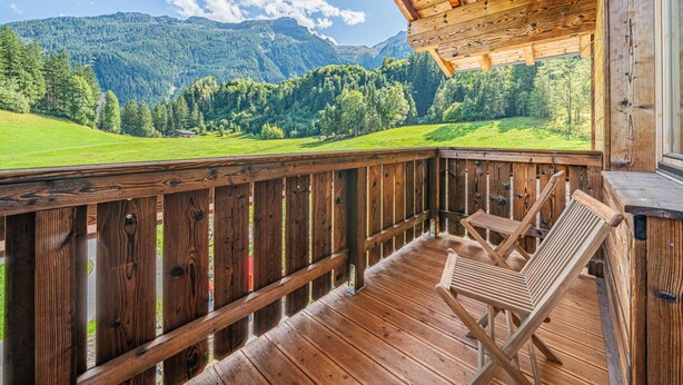 A wooden deck with a view of a mountainous landscape. - Cosy holiday flat with mountain views (Vorderkrimml)