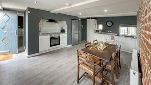 Una cucina moderna con pensili bianchi, forno integrato e microonde.