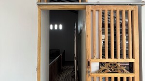 A hallway with a wooden door frame and a decorative metal gate.