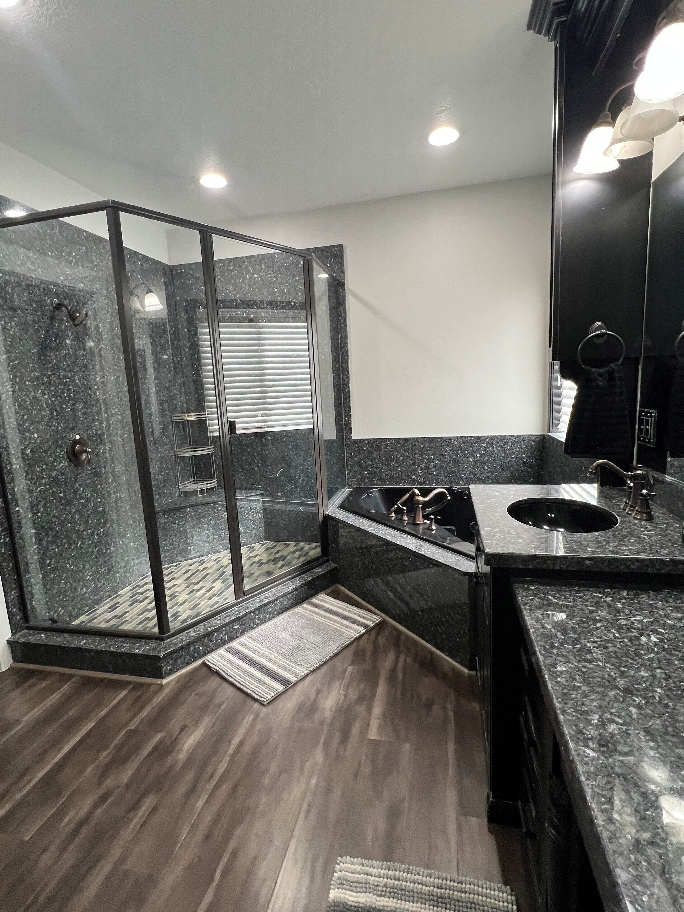 A modern bathroom with a glass-enclosed shower, a double sink vanity, and a large mirror.