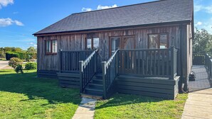 A wooden cabin with a porch and steps, surrounded by a grassy yard. - 3 bedroom accommodation in Brigg (Brigg)